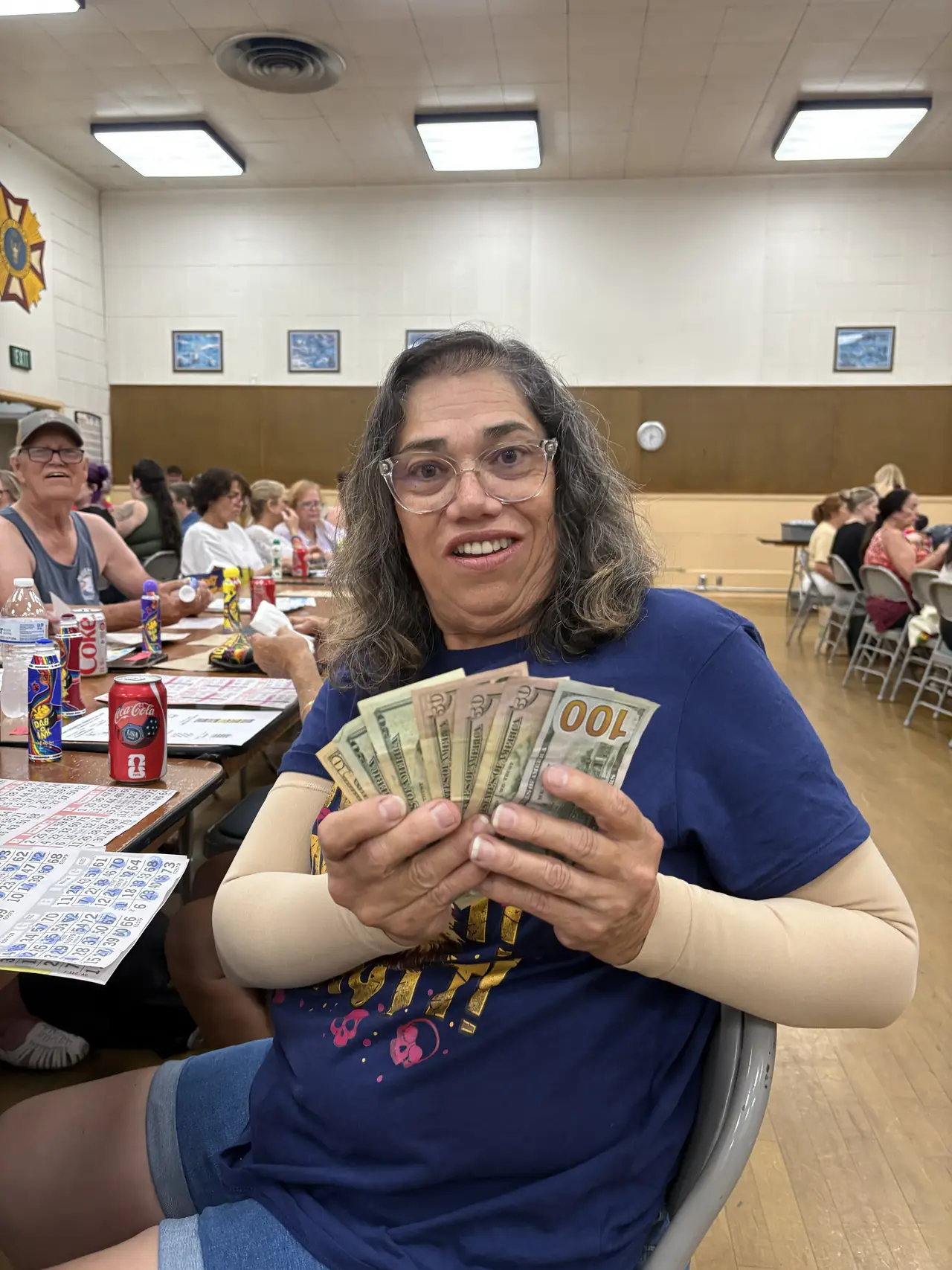 A Wine Country Bingo winner smiling and holding her cash prize.