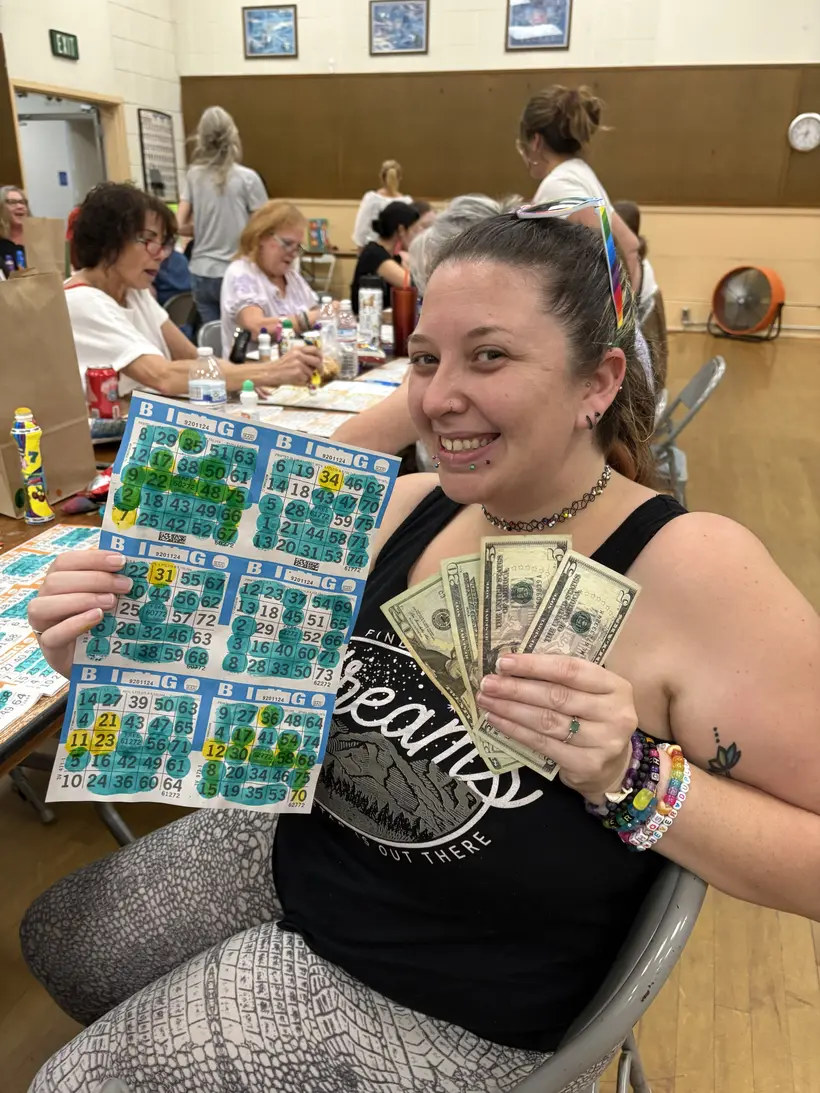A Wine Country Bingo winner showing her marked card and cash prize.