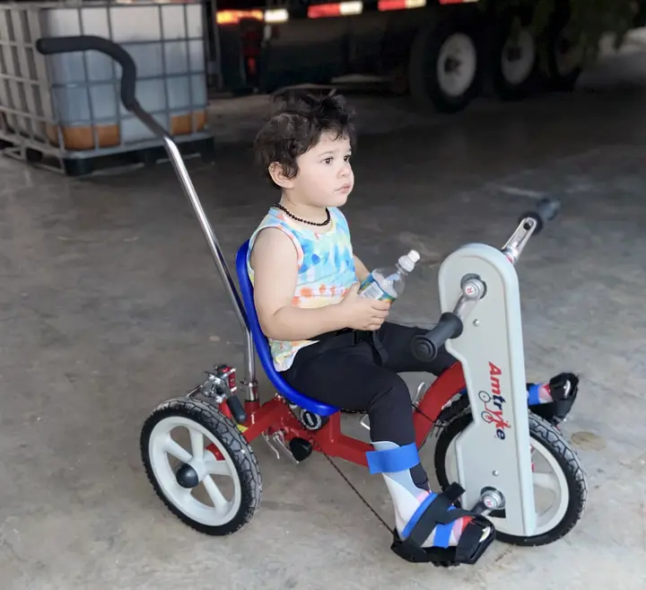 Lukas seated on his first adaptive Tryke.