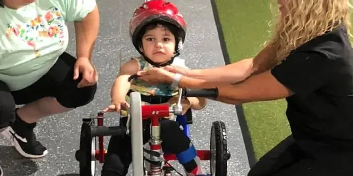 A young Lukas being fitted on his first adaptive Tryke.